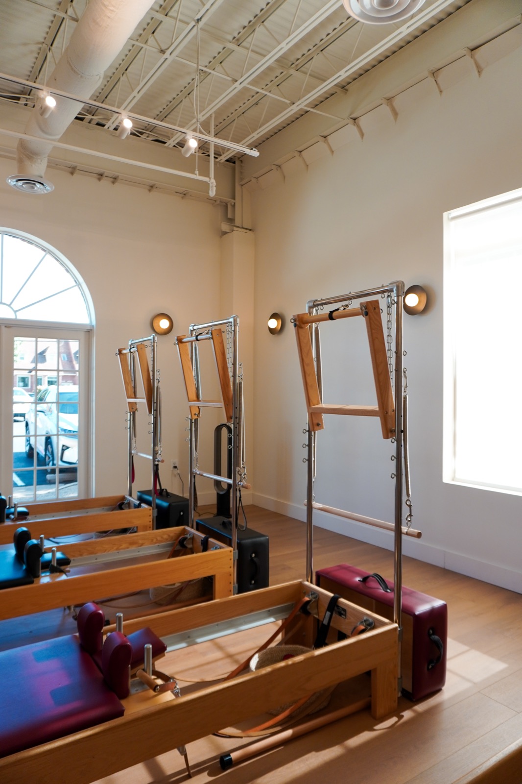 Reformer and tower equipment beside the studio's arched windows
